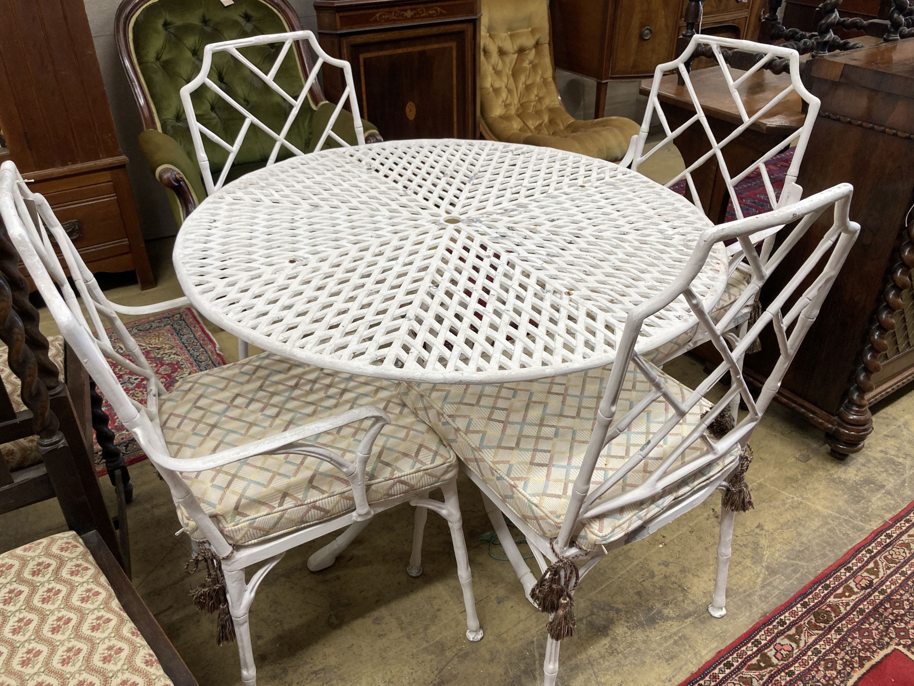 A faux bamboo circular garden table, 98cm diameter, height 72cm together with a set of four painted aluminium faux bamboo garden chairs, two with arms